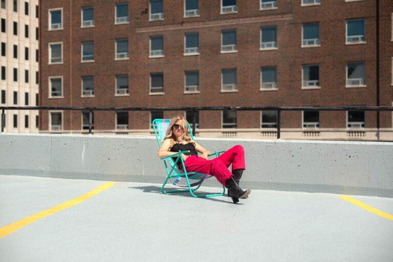 Abby Hamilton sitting in a chair on a roof-top parking lot space.