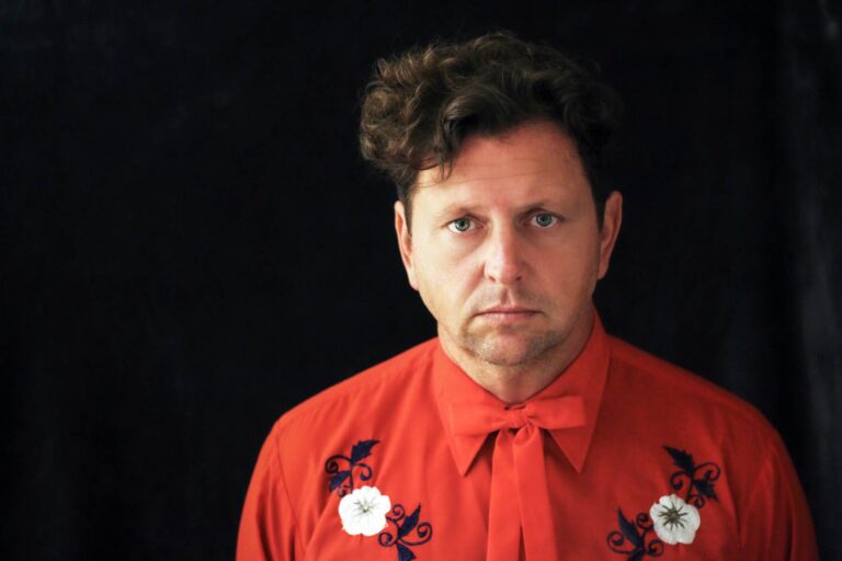 Portrait of a man with flower embroidered shirt.