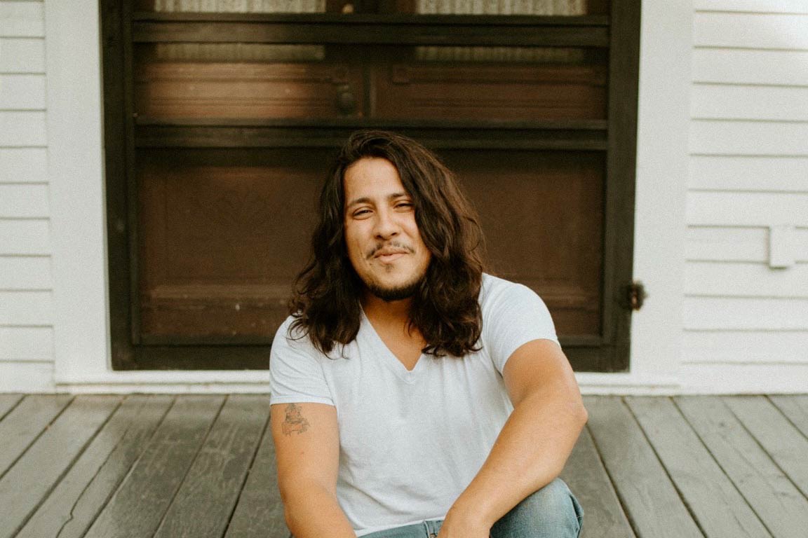 Man sitting on a house porch.