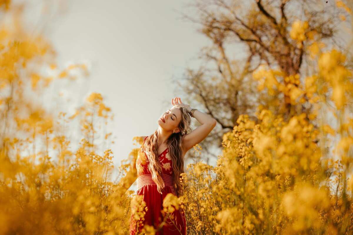 Stylized portrait of woman outdoors among yellow flowers