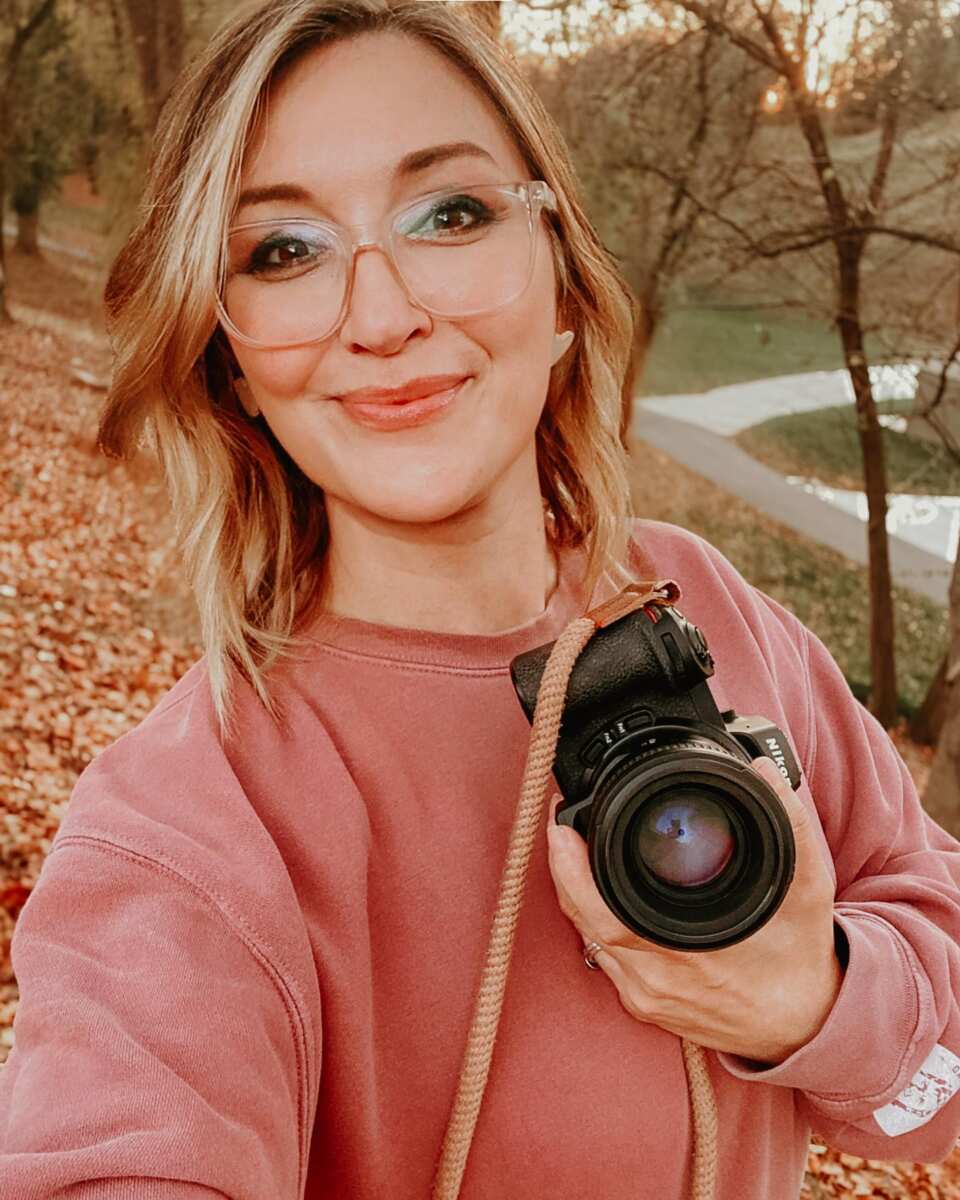 Woman holding camera outdoors