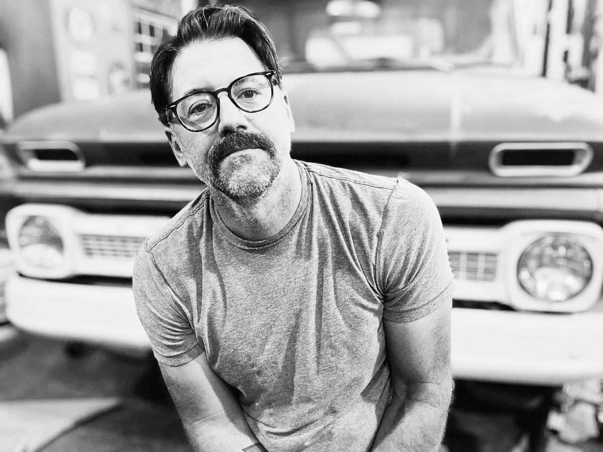 black and white photo of man with mustache and glasses