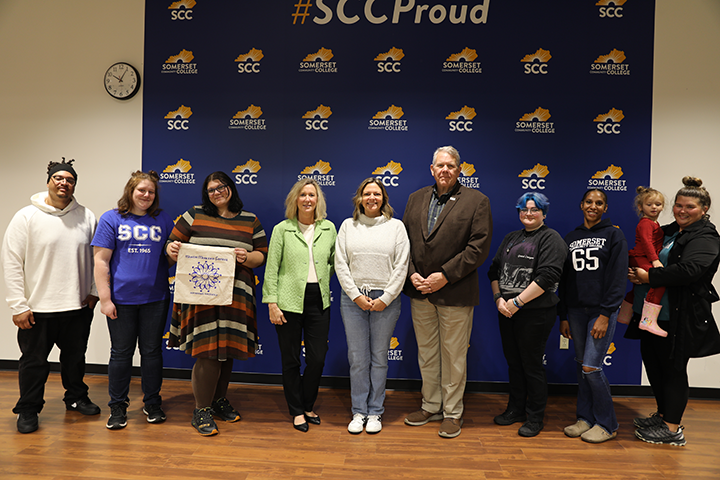 group of people standing in front of SCC background